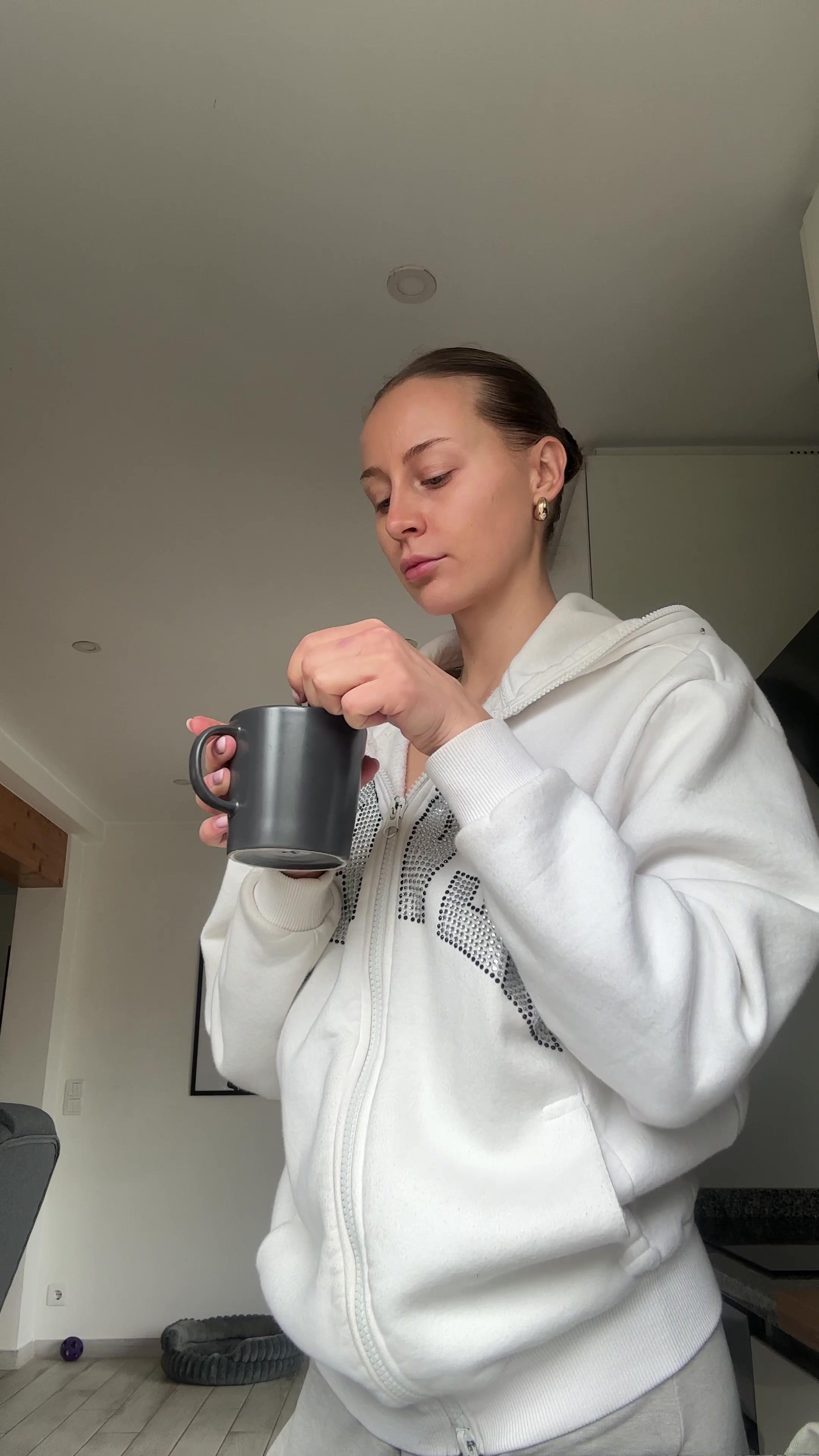 Woman Stirring and Sipping Warm Drink